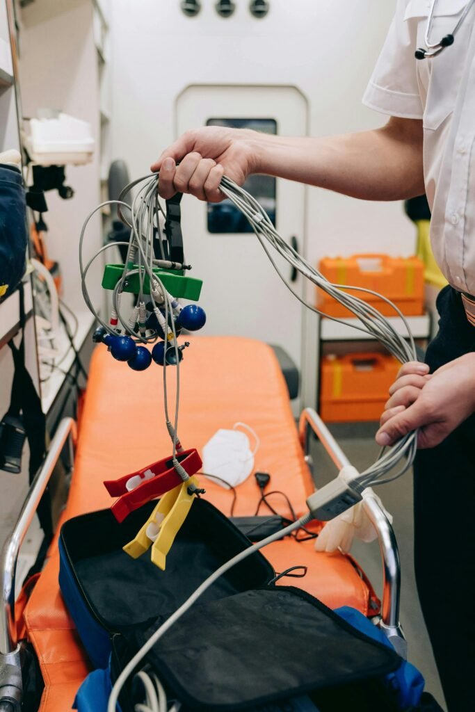 A paramedic handles ECG sensors in an ambulance, showcasing emergency medical care equipment.